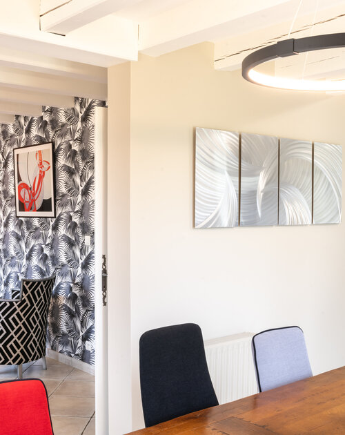 Transformation d'un salon- séjour pour intégrer un tableau de Kandinsky. Rénovation moderne en rouge et noir, tout en finesse et douceur. Le motif palmier du papier peint Krhoma apporte de la souplesse. Les luminaires valorisent les volumes.