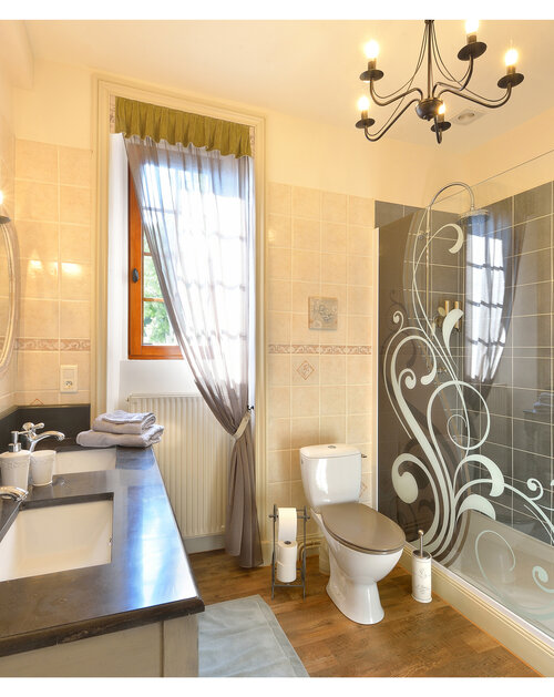 Chambre d'hôtes haut de gamme dans le château de Vernière - Cantal. La toile de Jouy mariée aux couleurs acidulées crée une ambiance originale. La salle de bain et le petit salon sont romantiques et fonctionnels. L'esprit authentique de cette suite est à l'image du château.