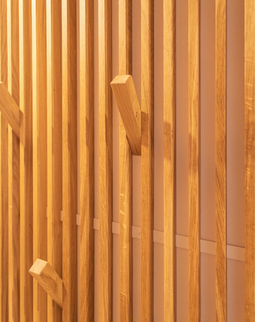 Pour valoriser un couloir tout en courbe, un magnifique panoramique de Glamora recouvre mur et portes pour une belle unité. Les tasseaux en bois donnent une perspective au couloir avec la mise en place de patères très fonctionnelles.